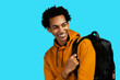 © Carlos David - young adult black man with backpack smiling looking away at copy space