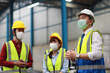 © feeling lucky - Group of technician engineer and businessman in protective uniform standing and discussing, researching, brainstorming and planning work together with protection mask at industry manufacturing factory