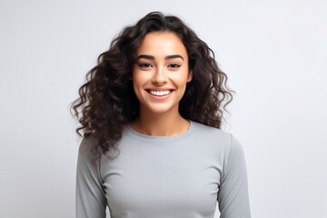 Wall Mural - Portrait of a beautiful young woman with curly hair smiling at camera.