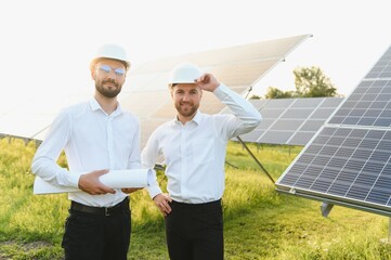 The solar farm(solar panel) with two engineers walk to check the operation of the system, Alternative energy to conserve the world's energy, Photovoltaic module idea for clean energy production