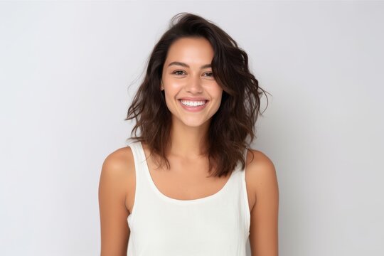 Portrait of beautiful young woman smiling and looking at camera on white background