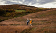 © Zoran Zeremski - Active senior couple with backpacks hiking together in nature on autumn day..