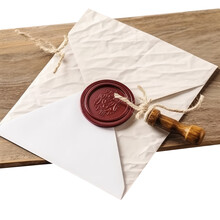 Top View Of Red Wax Sealed White Old Letter Envelope On Wooden Board.