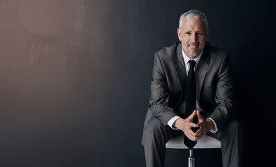 Sticker - Mock up, chair and happy portrait of lawyer, attorney or businessman with confidence on dark background in studio space. Boss, ceo or business owner with smile, senior executive director at law firm.