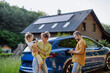 © Halfpoint - Family with little girl standing in front of their house with solar panels on the roof, having electric car.