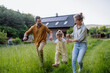 © Halfpoint - Family walking near their house with photovoltiacs panels on the roof.
