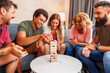 © Impact Photography - Friends having fun playing block stacking and removing balance game