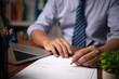 © khunkornStudio - Close up Hand businessman at office desk and signing a contract.