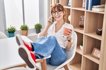 Poster - Young woman talking on the smartphone drinking coffee at home