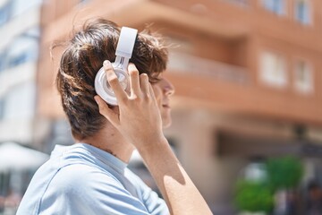 Poster - Young blond man listening to music at street