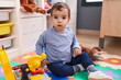 © Krakenimages.com - Adorable hispanic boy playing with tools toy sitting on floor at kindergarten