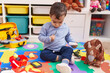 © Krakenimages.com - Adorable hispanic boy playing supermarket game sitting on floor at kindergarten