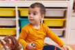 © Krakenimages.com - Adorable hispanic boy sitting on floor smiling at kindergarten