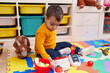 © Krakenimages.com - Adorable hispanic boy playing supermarket game sitting on floor at kindergarten