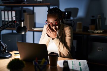 Sticker - Beautiful black woman working at the office at night shocked covering mouth with hands for mistake. secret concept.