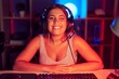 © Krakenimages.com - Young blonde woman playing video games wearing headphones winking looking at the camera with sexy expression, cheerful and happy face.