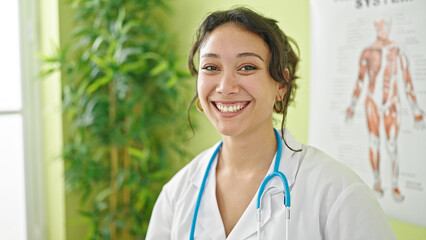 Poster - Young beautiful hispanic woman doctor smiling confident standing at clinic