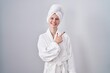 © Krakenimages.com - Blonde caucasian woman wearing bathrobe cheerful with a smile on face pointing with hand and finger up to the side with happy and natural expression
