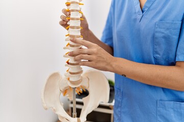 Sticker - Young blonde woman pysiotherapist touching anatomical model of vertebral column at rehab clinic