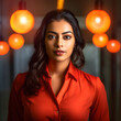 Confident Indian business woman wearing red shirt inside a modern office.