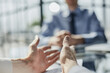 © Katsiaryna - hands on the table in the office against the background of a blurred colleague, close-up