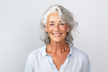 Portrait of a happy senior woman smiling at camera over grey background