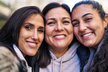 Wall Mural - Three woman mother and daughters standing together at street