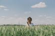 © Анастасія Стягайло - Portrait of a smiling boy in a white T-shirt and playing in a green barley field. Happy child boy laughing and playing in the summer day. Kid exploring nature. Summer activity for inquisitive children