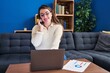 © Krakenimages.com - Young beautiful hispanic woman talking on smartphone using laptop at home