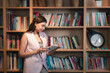 © flyalone - Young woman reading book. Young female student reading book at book store.
