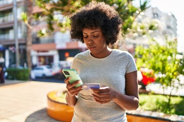 Poster - African american woman using smartphone and credit card at park