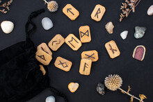 Black Textile Bag With Stack Of Wooden Runes And Stones On A Table. Scandinavian Magical Esoteric Symbols And Signs For Divination And Prediction Of The Future And Destiny, Top View.