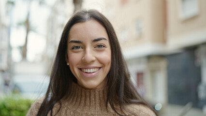 Wall Mural - Young beautiful hispanic woman smiling confident standing at street