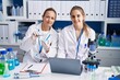 © Krakenimages.com - Two women scientists using laptop holding pill at laboratory