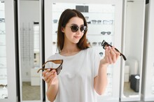 Young Woman Chooses Sunglasses For Herself In An Optics Store
