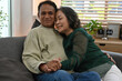 © saltdium - A heartwarming portrait of an elderly Asian couple embracing and holding hands with love at home.