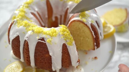 Wall Mural - Step by step. Slicing lemon bundt cake decorated with lemon zest on a cake stand.