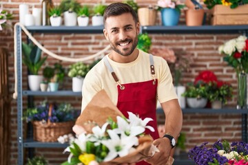 Canvas Print - Young hispanic man florist holding bouquet of flowers at florist