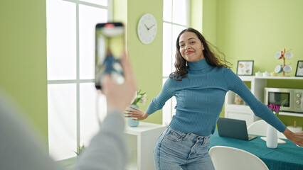 Sticker - Young beautiful hispanic woman dancing recording online tutorial for social networks at home