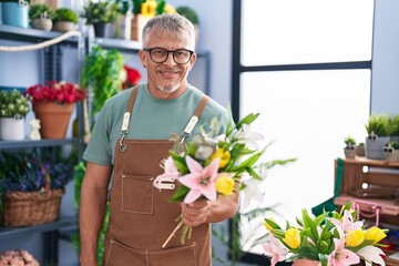 Poster - Middle age grey-haired man florist holding bouquet of flowers at flower shop