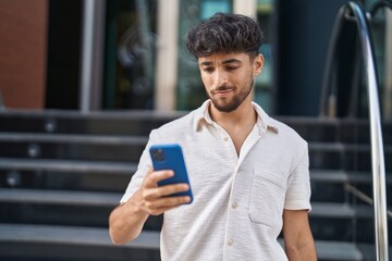 Sticker - Young arab man using smartphone at street