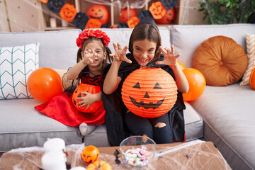 Canvas Print - Adorable boy and girl having halloween party doing fear gesture at home