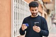 © Krakenimages.com - Young arab man using smartphone and credit card at street