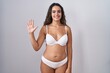 © Krakenimages.com - Young hispanic woman wearing white lingerie showing and pointing up with fingers number five while smiling confident and happy.