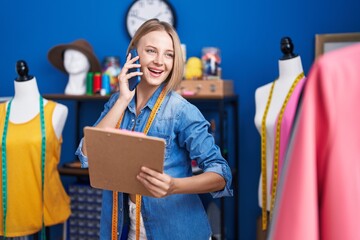 Poster - Young blonde woman tailor talking on smartphone reading document at sewing studio