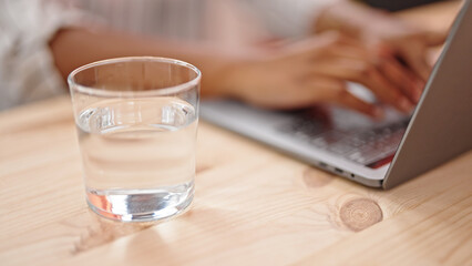 African american woman using laptop sitting on table at dinning room