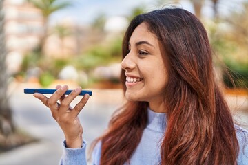 Poster - Young hispanic woman smiling confident talking on the smartphone at street