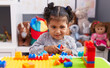 © Krakenimages.com - Adorable hispanic girl playing with construction blocks sitting on table at kindergarten