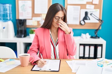 Canvas Print - Young hispanic woman working at the office wearing glasses tired rubbing nose and eyes feeling fatigue and headache. stress and frustration concept.