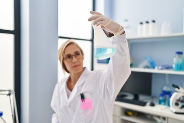 Wall Mural - Young blonde woman scientist holding test tube at laboratory